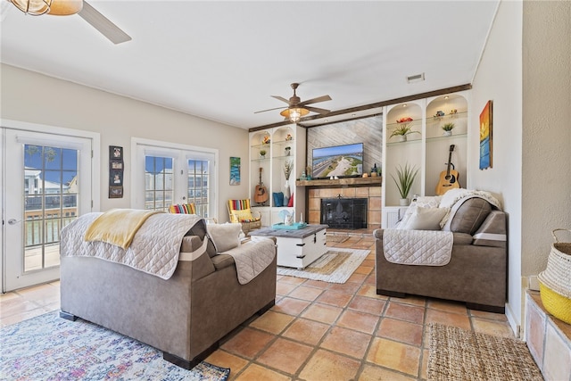 living room featuring built in shelves, ceiling fan, a wealth of natural light, and french doors