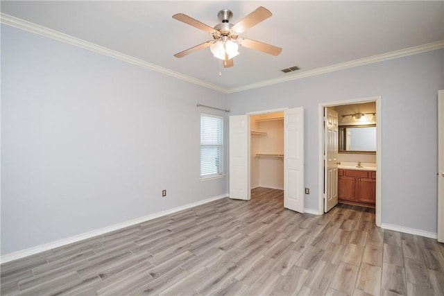 6513 Purplewing Dr, Corpus Christi, TX 78414 - unfurnished bedroom featuring light wood finished floors, crown molding, a closet, baseboards, and a walk in closet