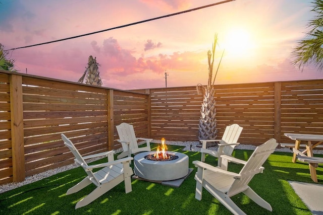 patio terrace at dusk with a yard and an outdoor fire pit