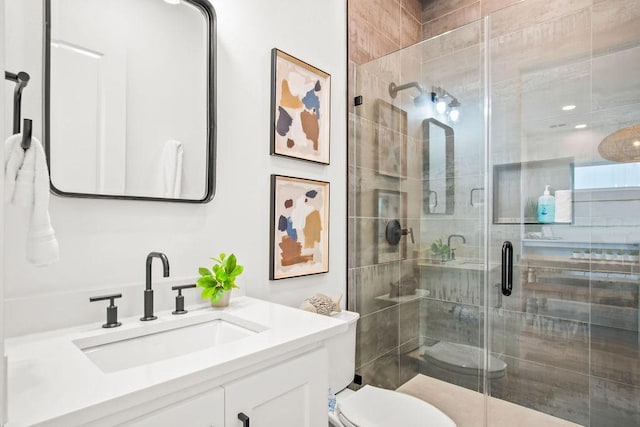 bathroom with vanity, toilet, and a shower with shower door