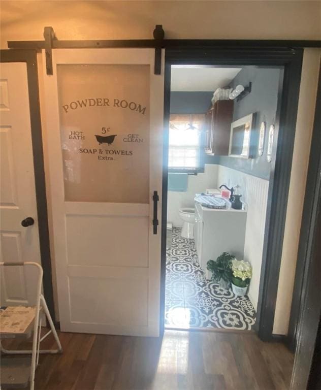 doorway to outside with a barn door and dark wood-type flooring