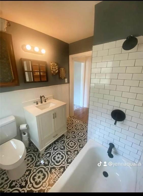 full bathroom with tiled shower / bath, vanity, toilet, and tile patterned flooring