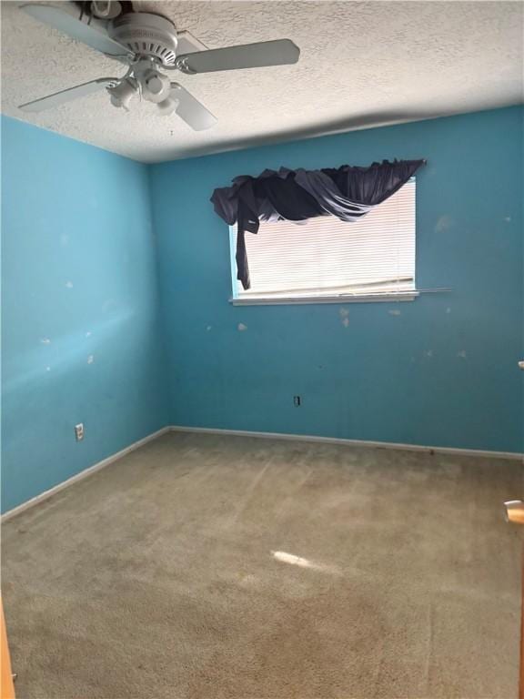 carpeted spare room featuring ceiling fan and a textured ceiling