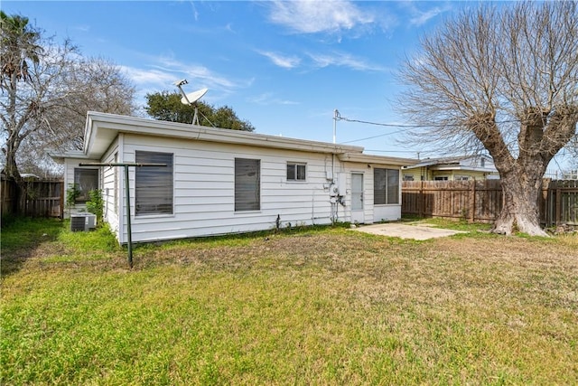 rear view of property featuring a patio, central AC unit, a lawn, and fence private yard