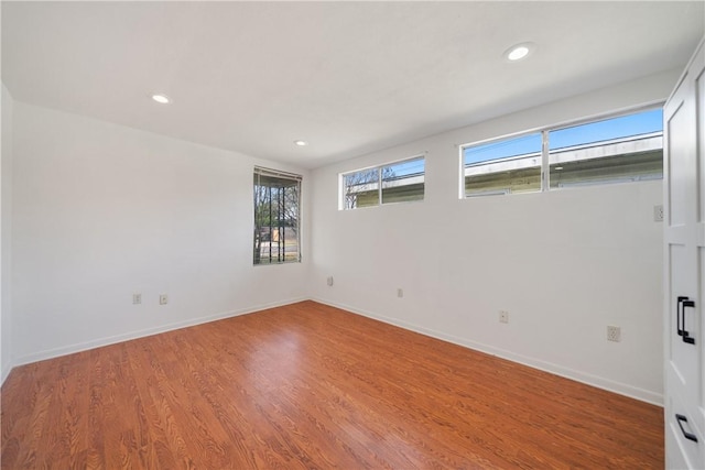 empty room with recessed lighting, baseboards, and wood finished floors