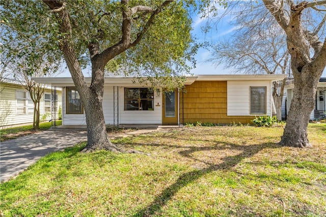 ranch-style house featuring concrete driveway and a front lawn