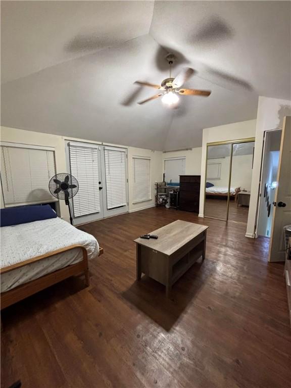 bedroom featuring multiple closets, ceiling fan, dark wood-type flooring, and vaulted ceiling