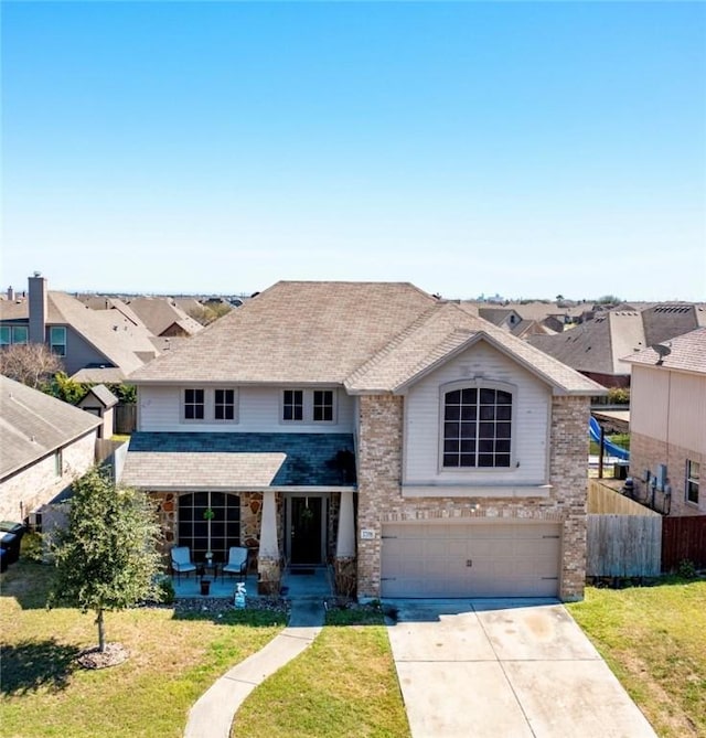 view of front of property with a front yard, covered porch, driveway, and fence