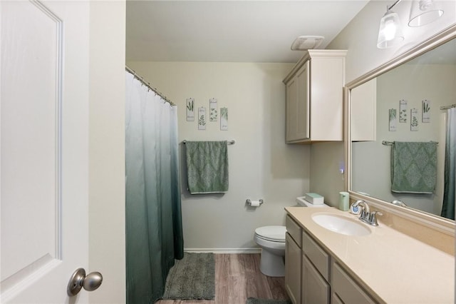 bathroom featuring toilet, a shower with shower curtain, wood finished floors, vanity, and baseboards