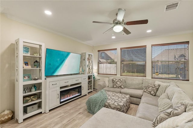 living area with recessed lighting, visible vents, ornamental molding, a ceiling fan, and light wood-type flooring