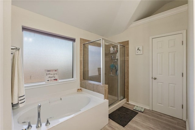 bathroom featuring vaulted ceiling, wood finished floors, a shower stall, and a bath