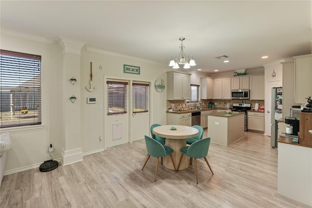 dining room featuring ornamental molding, a chandelier, light wood-style flooring, and baseboards