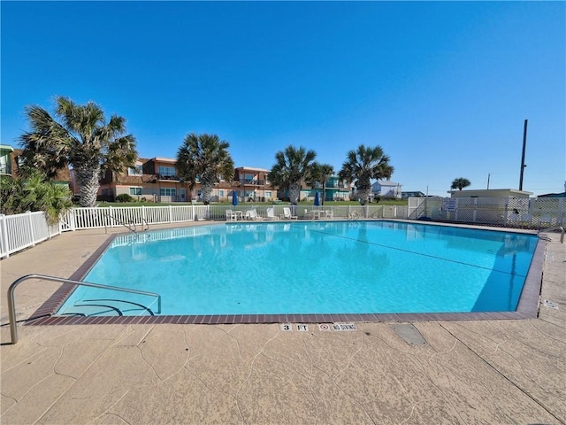 community pool featuring a patio area and fence