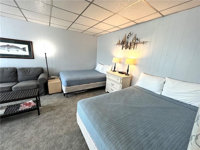 bedroom with dark carpet and a paneled ceiling