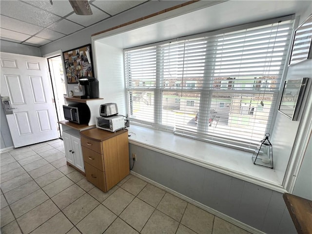 home office featuring light tile patterned floors and a drop ceiling