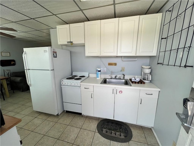 kitchen featuring a paneled ceiling, white appliances, a sink, white cabinetry, and light countertops