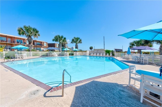 pool with a patio and fence