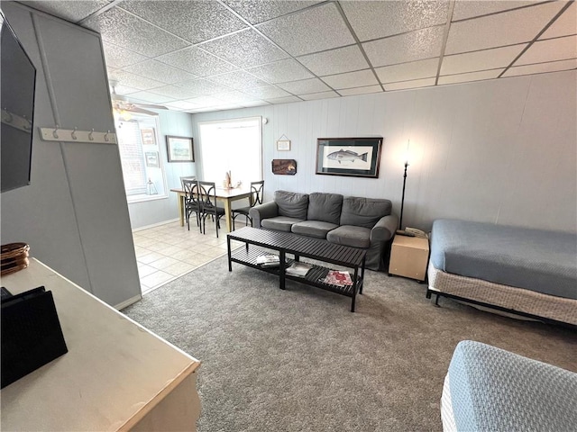 living room featuring a drop ceiling and carpet flooring