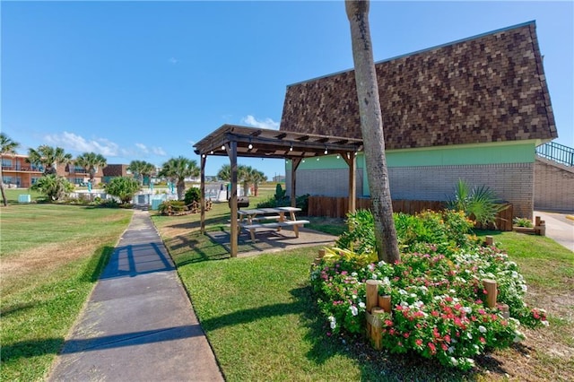 view of home's community with a lawn, fence, and a pergola