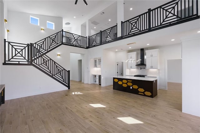 living room with a high ceiling and light hardwood / wood-style floors