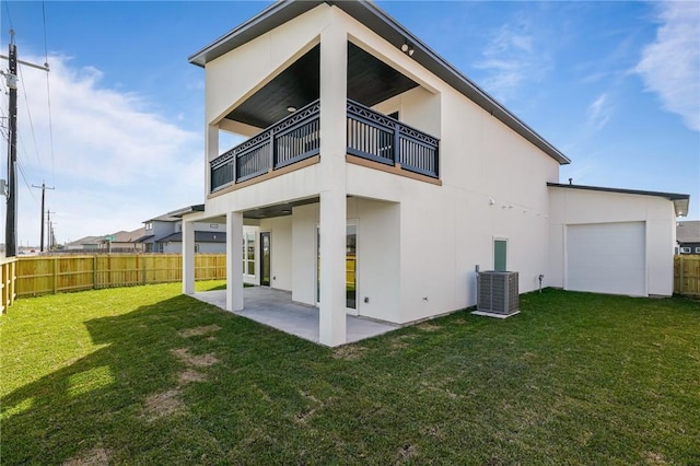 back of property with a balcony, a patio area, central AC, and a lawn