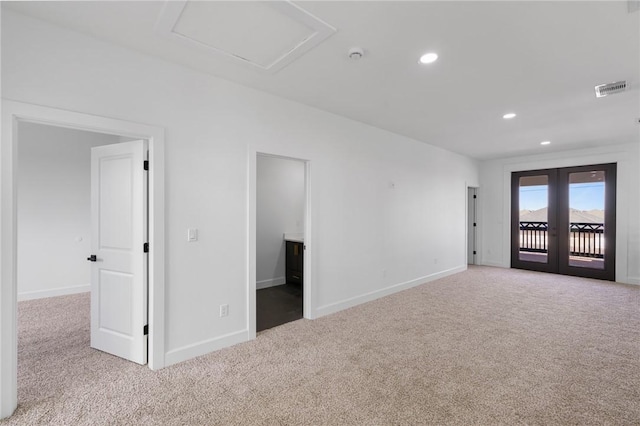 carpeted spare room featuring french doors