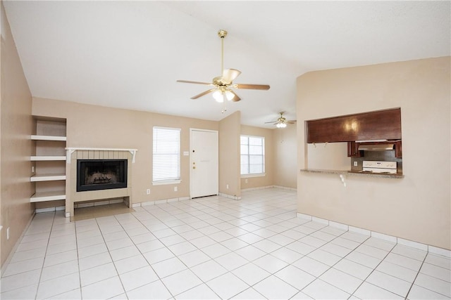 unfurnished living room featuring ceiling fan, light tile patterned floors, and vaulted ceiling