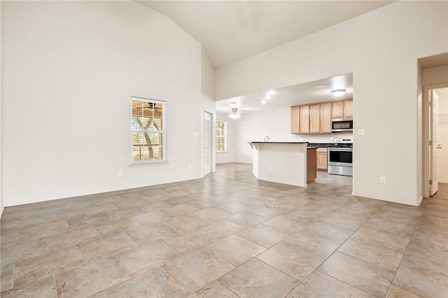 unfurnished living room featuring ceiling fan and high vaulted ceiling