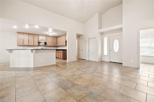 kitchen with high vaulted ceiling and a kitchen breakfast bar