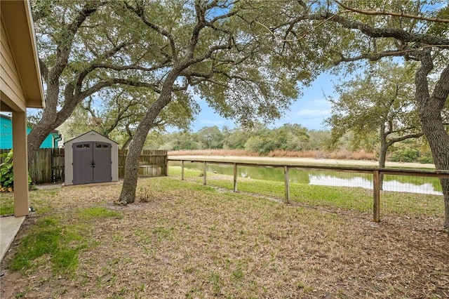 view of yard featuring a storage unit and a water view