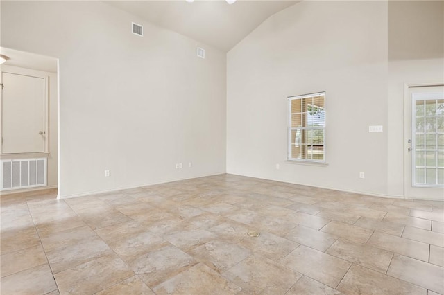 spare room with a healthy amount of sunlight and high vaulted ceiling