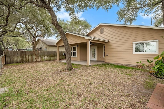 back of house with a patio area and a lawn