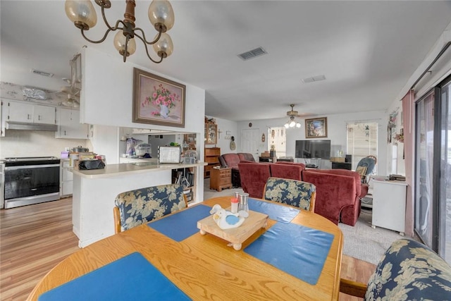 3410 Laguna Shrs, Corpus Christi, TX 78418 - dining room featuring light wood finished floors, a ceiling fan, and a chandelier