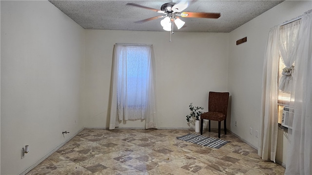 empty room with ceiling fan, plenty of natural light, cooling unit, and a textured ceiling