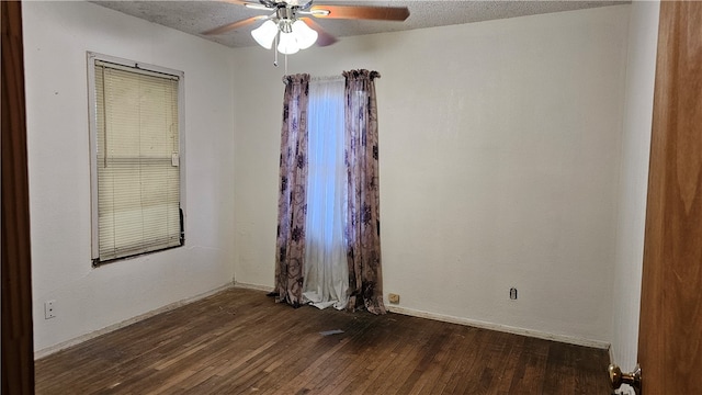 empty room with a textured ceiling, dark wood-type flooring, and ceiling fan