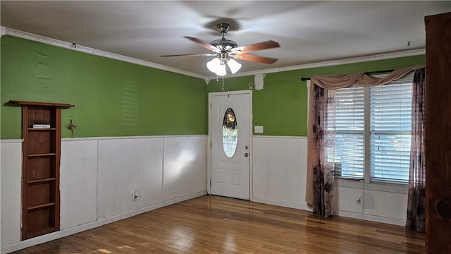 entrance foyer with ceiling fan, a wealth of natural light, hardwood / wood-style floors, and ornamental molding