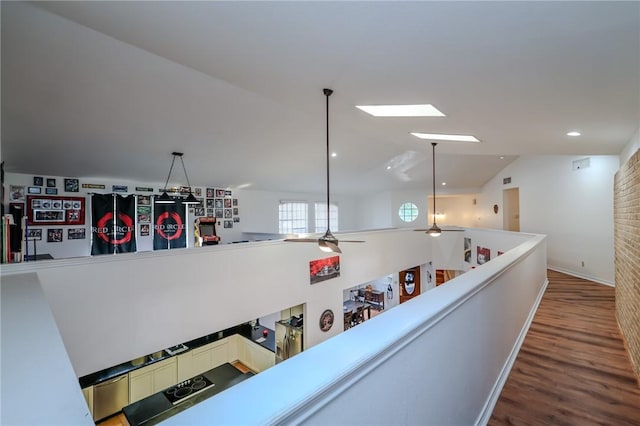 hallway with vaulted ceiling and dark wood-type flooring