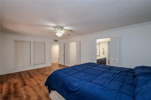 bedroom with hardwood / wood-style floors, ceiling fan, ornamental molding, a textured ceiling, and connected bathroom