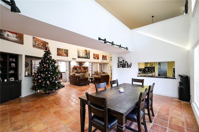 dining area with tile patterned flooring and a towering ceiling