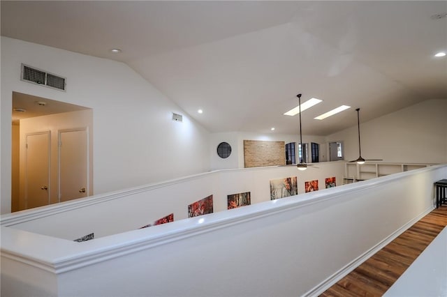 hall with lofted ceiling and hardwood / wood-style flooring