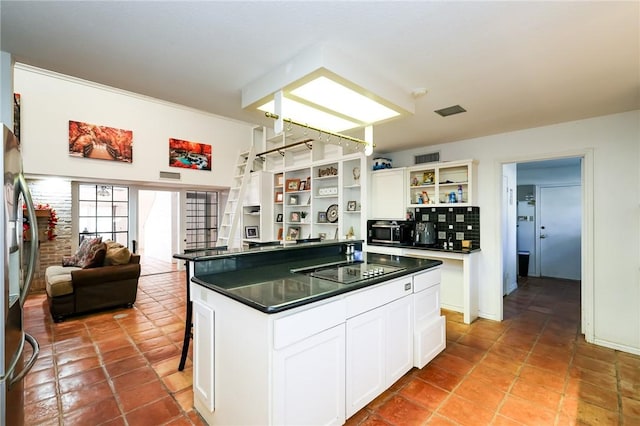 kitchen featuring backsplash, black appliances, a kitchen island, white cabinetry, and a breakfast bar area