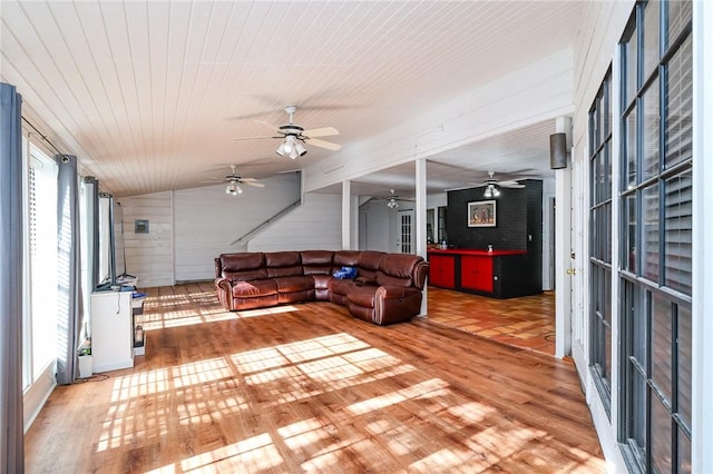 living room featuring a wealth of natural light, light hardwood / wood-style flooring, and vaulted ceiling