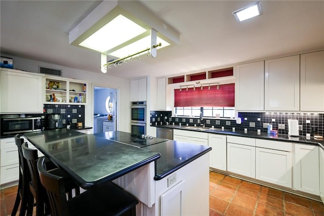 kitchen featuring a breakfast bar area, white cabinets, and stainless steel appliances