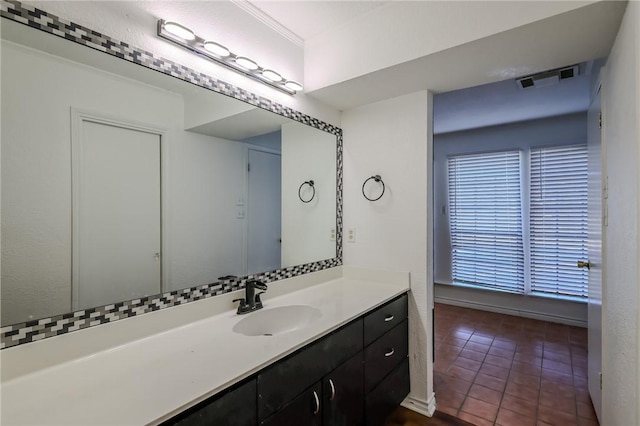 bathroom featuring tile patterned flooring, vanity, a wealth of natural light, and ornamental molding