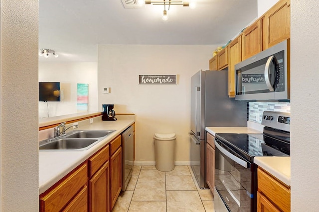 kitchen featuring decorative backsplash, appliances with stainless steel finishes, sink, and light tile patterned flooring