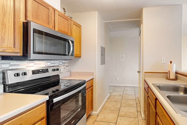 kitchen with decorative backsplash, appliances with stainless steel finishes, sink, and light tile patterned floors