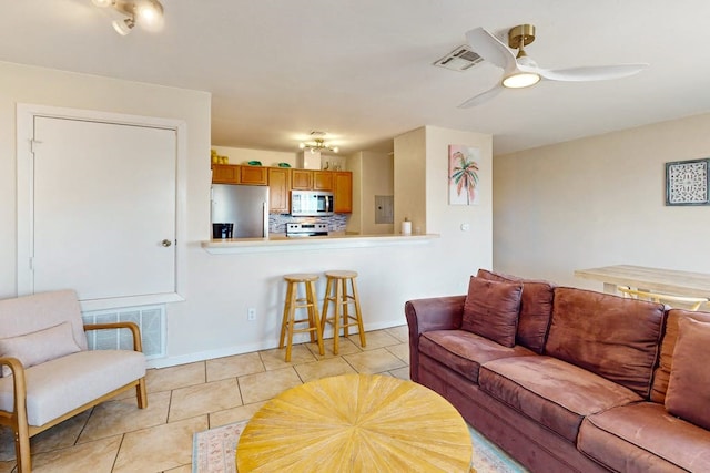 living room with electric panel, light tile patterned flooring, and ceiling fan