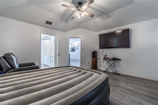 bedroom with hardwood / wood-style floors, ensuite bath, ceiling fan, and vaulted ceiling