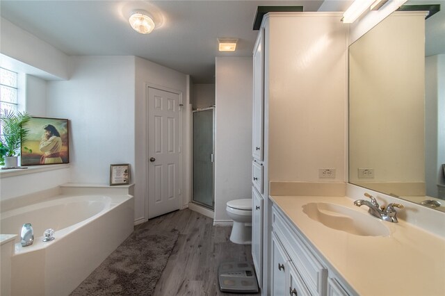 full bathroom featuring toilet, independent shower and bath, vanity, and hardwood / wood-style floors