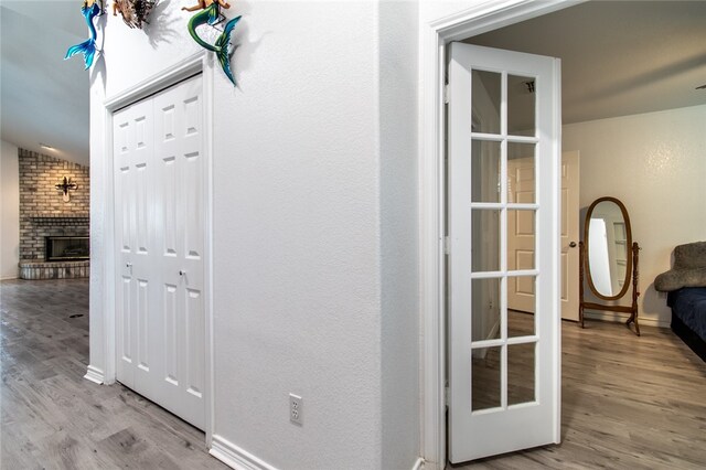 corridor with lofted ceiling and light hardwood / wood-style flooring